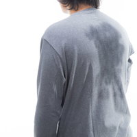 グレーのシャツに大きく広がった汗ジミの背中の写真