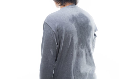 グレーのシャツに大きく広がった汗ジミの背中