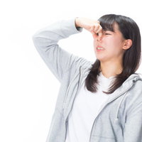 体臭や悪臭に顔を歪めて鼻をつまむ女性のポートレートの写真