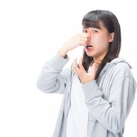 悪臭で息が詰まり鼻をつまむ女性の不快な表情の写真