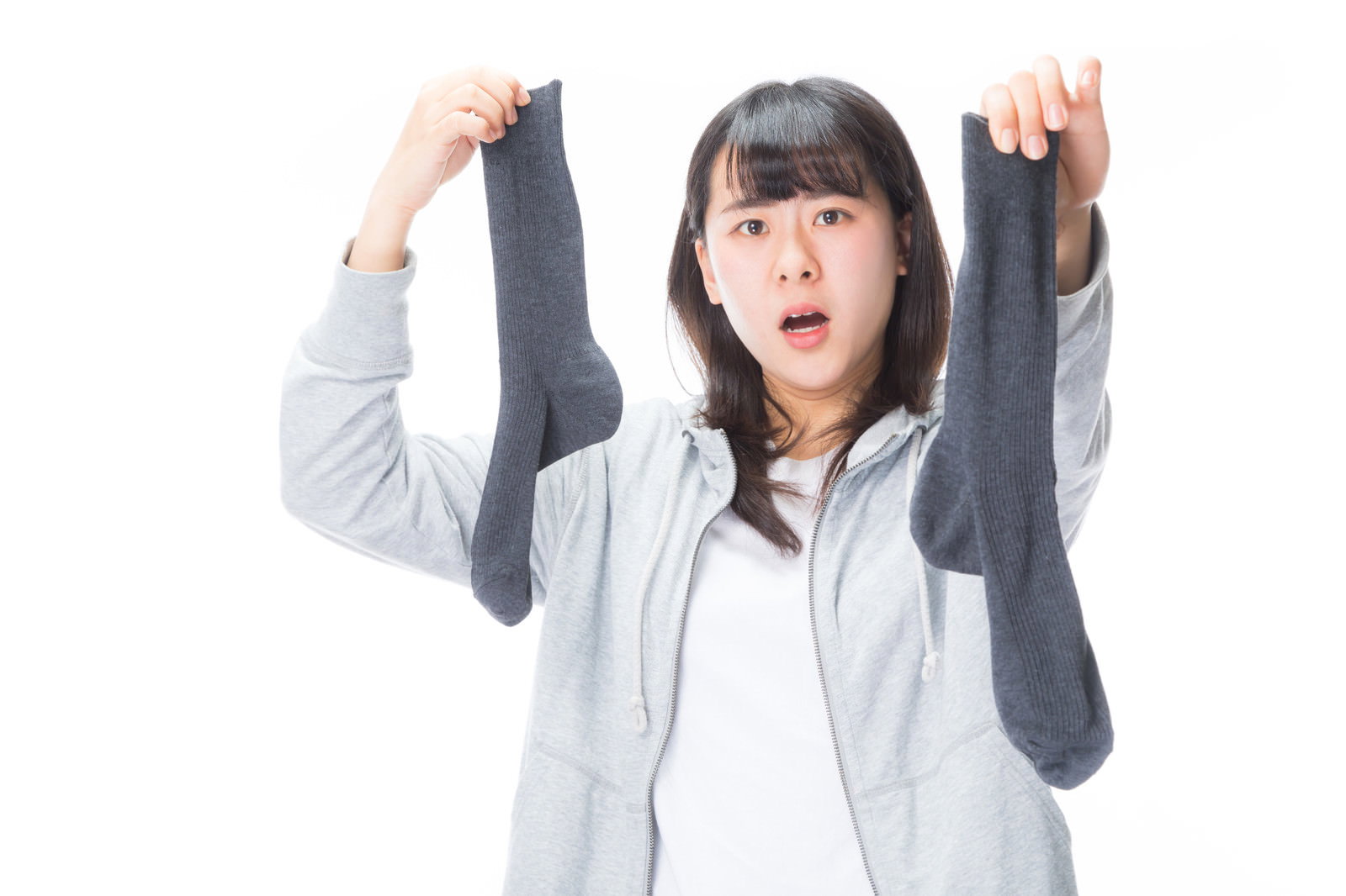 悪臭に顔をゆがめ両手で鼻を押さえるグレーパーカーの女性［モデル：Mizuho］