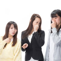 悪臭に耐えきれず鼻をつまむ女性三人の体臭注意喚起の写真