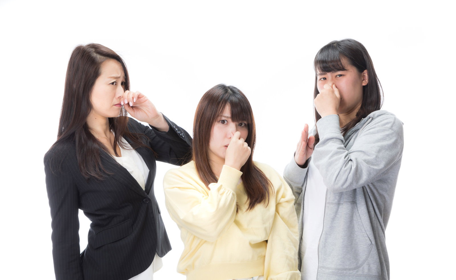 鼻を手で覆って嫌がる表情を見せる3人の女性［モデル：Lala Mizuho 土本寛子］