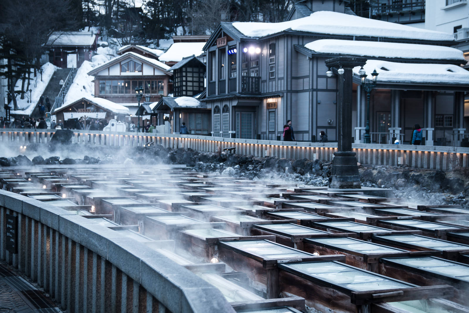 雪に覆われた草津温泉の湯畑から湯けむりが立ち上る冬景色