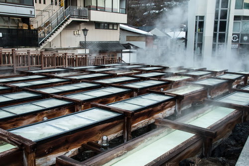 ズラリと並ぶ木の樋から湯けむりが立ち上る草津温泉湯畑