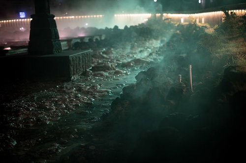 ライトアップされた湯畑と立ち上る湯気（草津温泉）