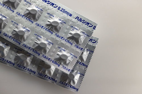 睡眠導入剤ハルシオンの白い錠剤と青いパッケージ