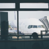 空港の搭乗ゲートで待つ旅客機と搭乗客たちの写真