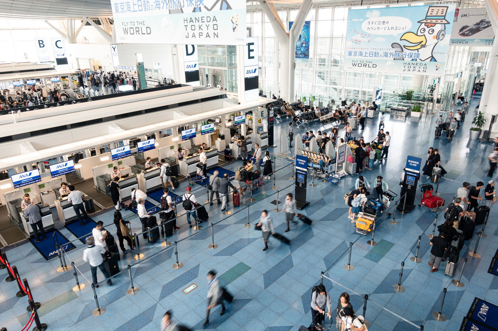 羽田空港の手荷物カウンターに並ぶ多くの旅行者たち