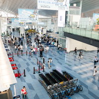 羽田空港第三ターミナルの開放的な通路と搭乗客の移動風景の写真