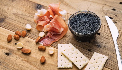 黒いキャビアと薄切りの生ハム、アーモンド、クラッカーの盛り合わせ