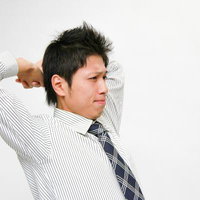 ネクタイ姿で背伸びするシャツの社員のストレッチの写真