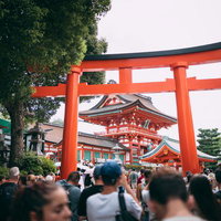 伏見稲荷大社の朱色大鳥居前に集まる大勢の外国人観光客たちの写真