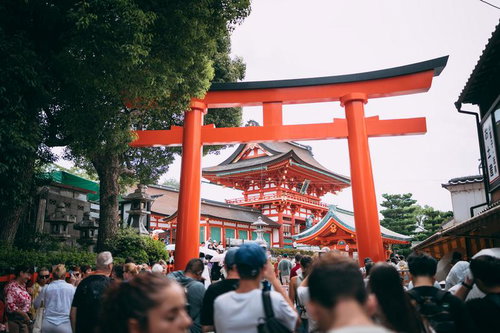 伏見稲荷大社の朱色大鳥居前に集まる大勢の外国人観光客たち