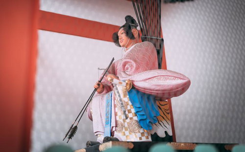 朱色の衣装と弓矢を持つ伏見稲荷大社の随神像