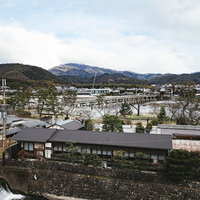 京都嵐山の渡月橋付近の桂川沿い風景と山間の工事現場の写真