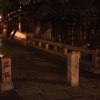 京都・祇園白川の夜間を照らす古橋と提灯の風情ある町並みの写真