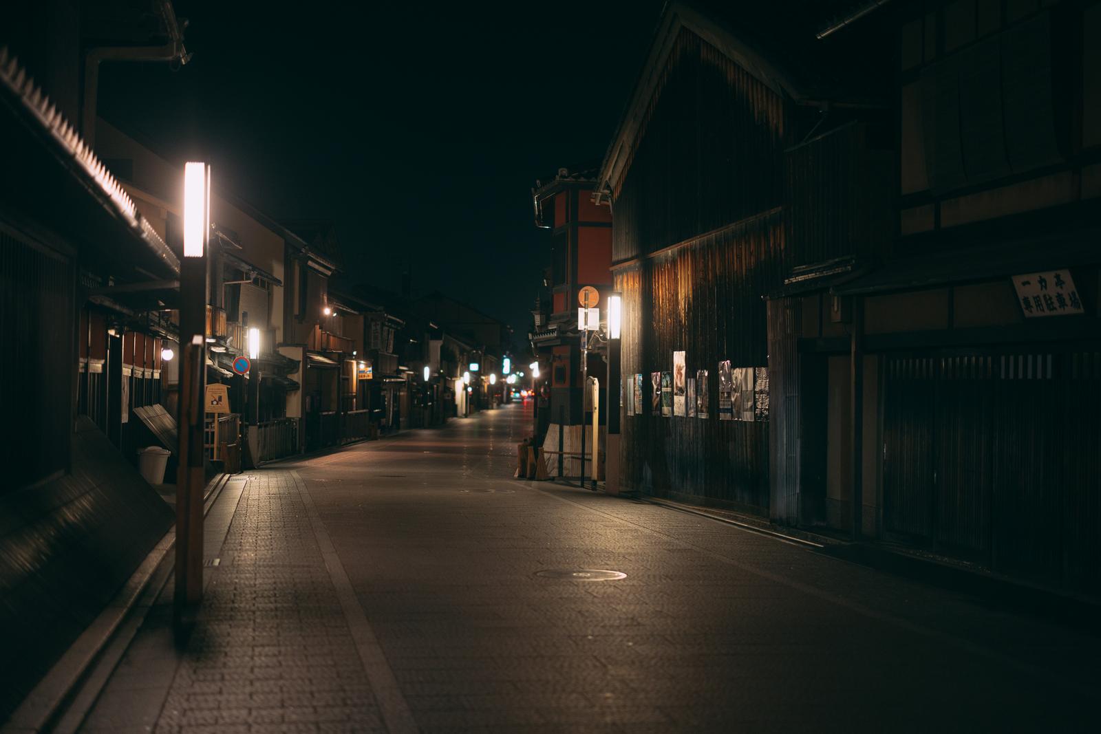 石畳の路地に街灯が灯り、伝統的な木造建築が並んでいる夜の風景