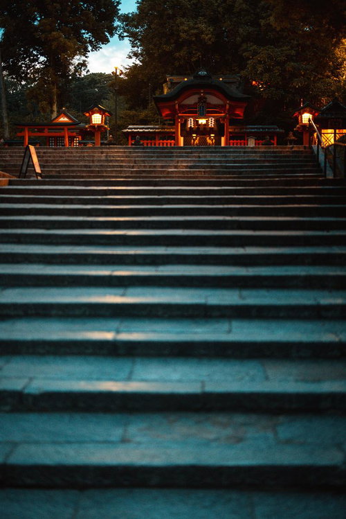夜間にライトアップされた伏見稲荷の朱色の建築と石段