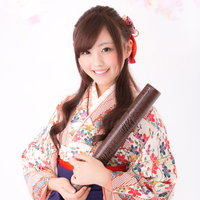 卒業証書を持った花柄の着物に紺色の袴姿の女性の写真