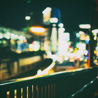 ボケ味ある夜の街のネオンと手すり、都市の光と奥行きの写真