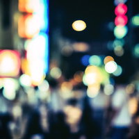 賑やかな夜の繁華街、ネオンと街灯がボケて光る夜景の写真