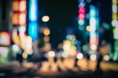 ネオン灯りが丸ボケになる夜間の繁華街の夜景