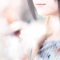 女性の口元と白い花のアップの写真