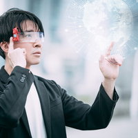 ARグラスでホログラム地球に触れるビジネスマンの写真