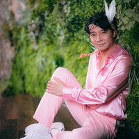 ピンクスーツで宣材撮影中のスター、ヘッドドレス付きの男性アイドルの写真