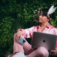 ノートパソコンを持つ社長業とアイドル活動を両立させる男性の写真