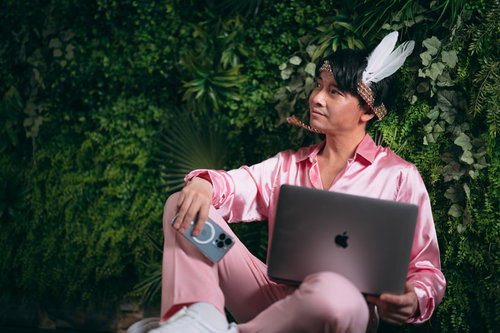 ノートパソコンを持つ社長業とアイドル活動を両立させる男性