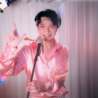 ピンクのシャツでマイクを握り熱唱するアイドル志願の男性の写真