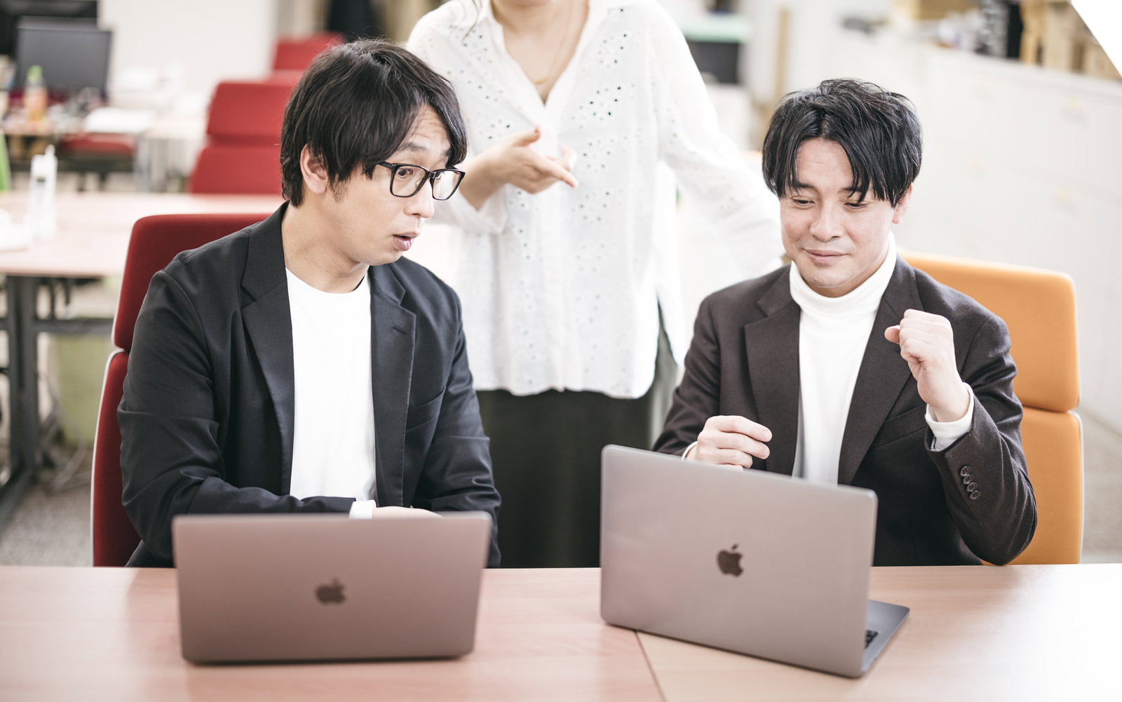 オフィスでMacBookを前に打ち合わせする3人［モデル：金子周平 大川竜弥］