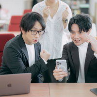 自社アプリが驚異的なダウンロード数を達成してガッツポーズする社員たちの写真