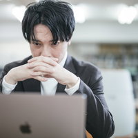 経営危機に直面した経営者がノートパソコンの画面をただ見つめる日々の写真