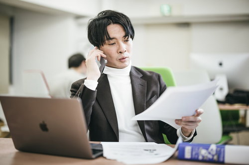 電話で見積りをダメだしする男性統括マネージャー