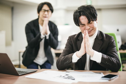 運頼みの入札案件で祈願する男性ビジネスパーソン