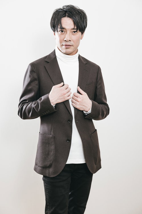 ブラウンのテーラードジャケットを着たCEOの宣材