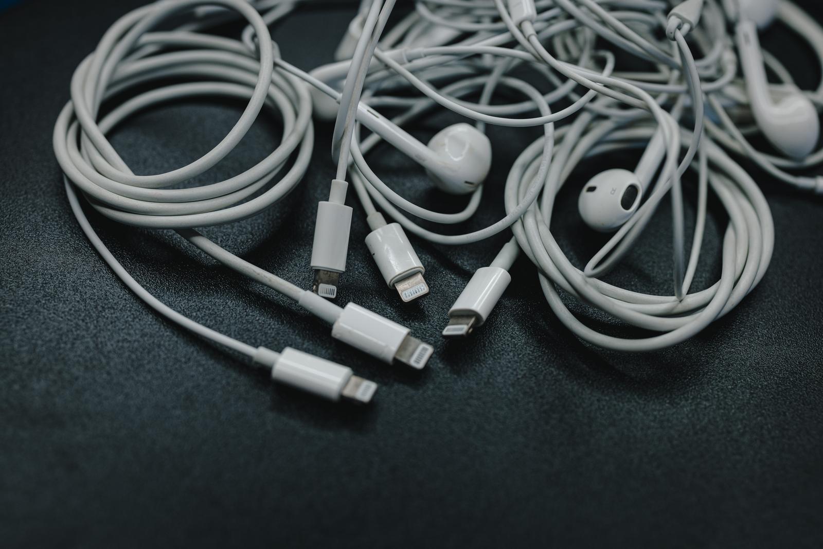 複数のLightningケーブルとEarPodsが絡まってい