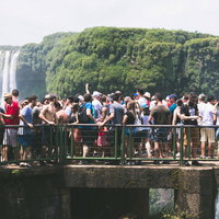 滝の上の遊歩道に群がるツアー客、イグアスの滝の展望台の写真