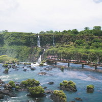 イグアスの滝の展望台で待つ観光客の行列と壮大な滝の景観の写真
