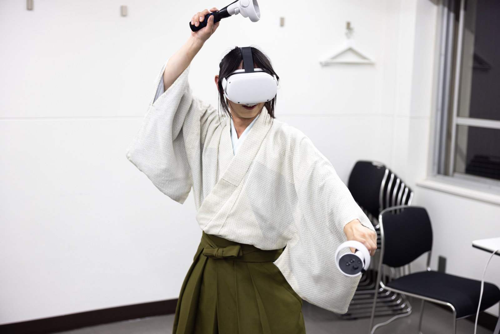 着物と袴を着てVRヘッドセットとコントローラーを使用している人［モデル：まーこ］