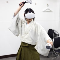 和装して Oculus Quest 2 のコントローラーを操るの写真