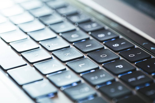 グレーのMacbookキーボードを斜めから捉えた