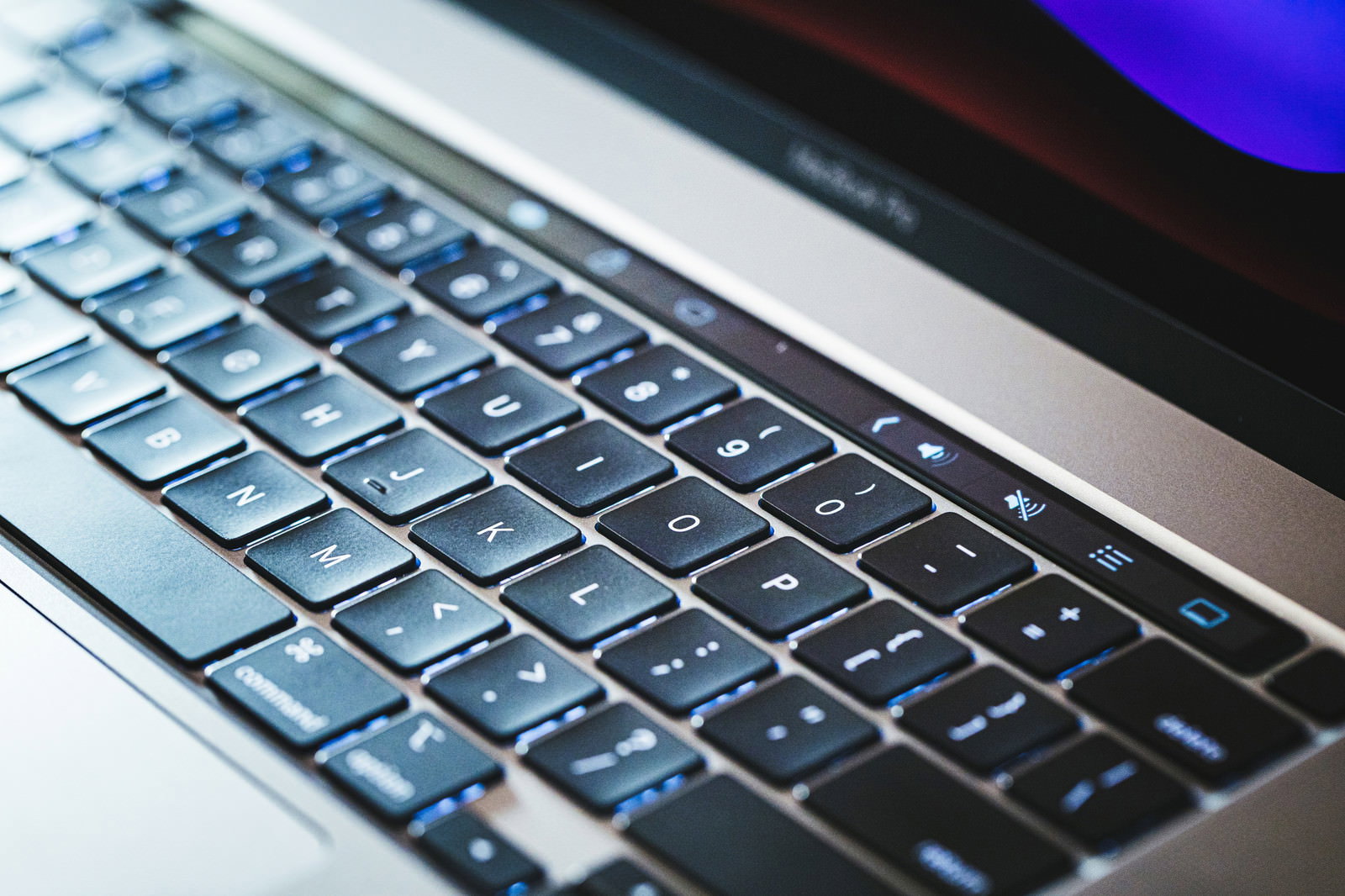 照明が当たるMacBookのキーボード部分のクローズアップ