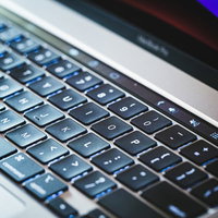 柔らかな照明が当たるMacBookのキーボードの写真