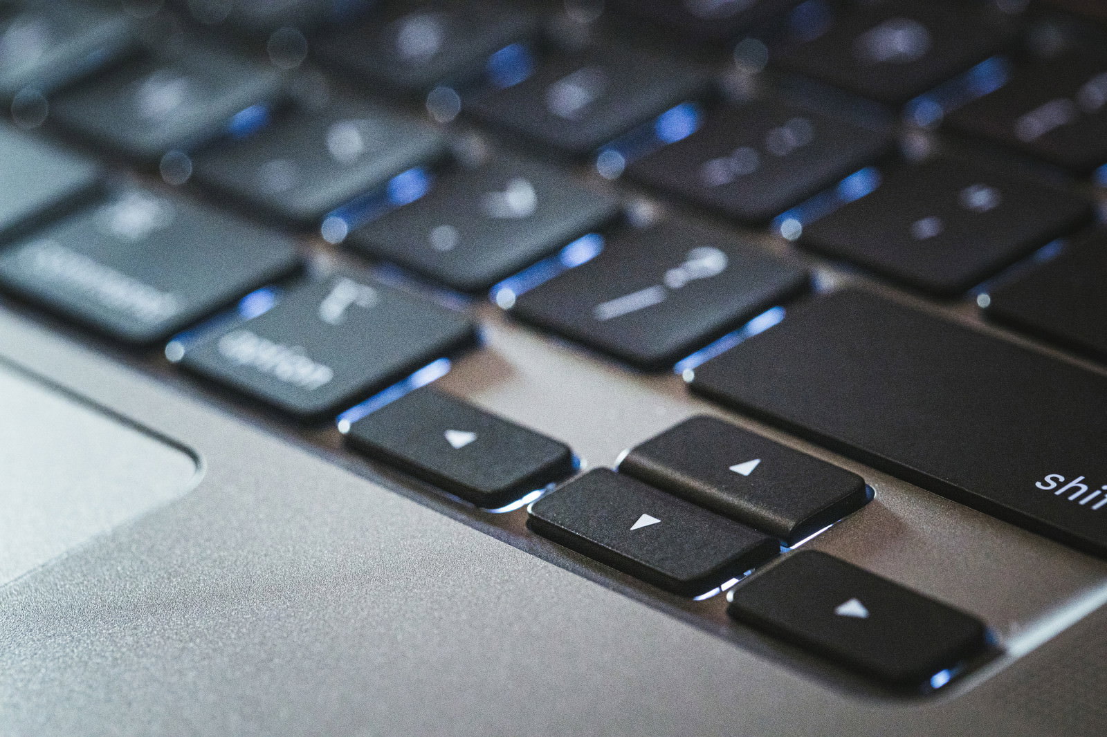 青いバックライトが点灯したMacBookのキーボード右下部分