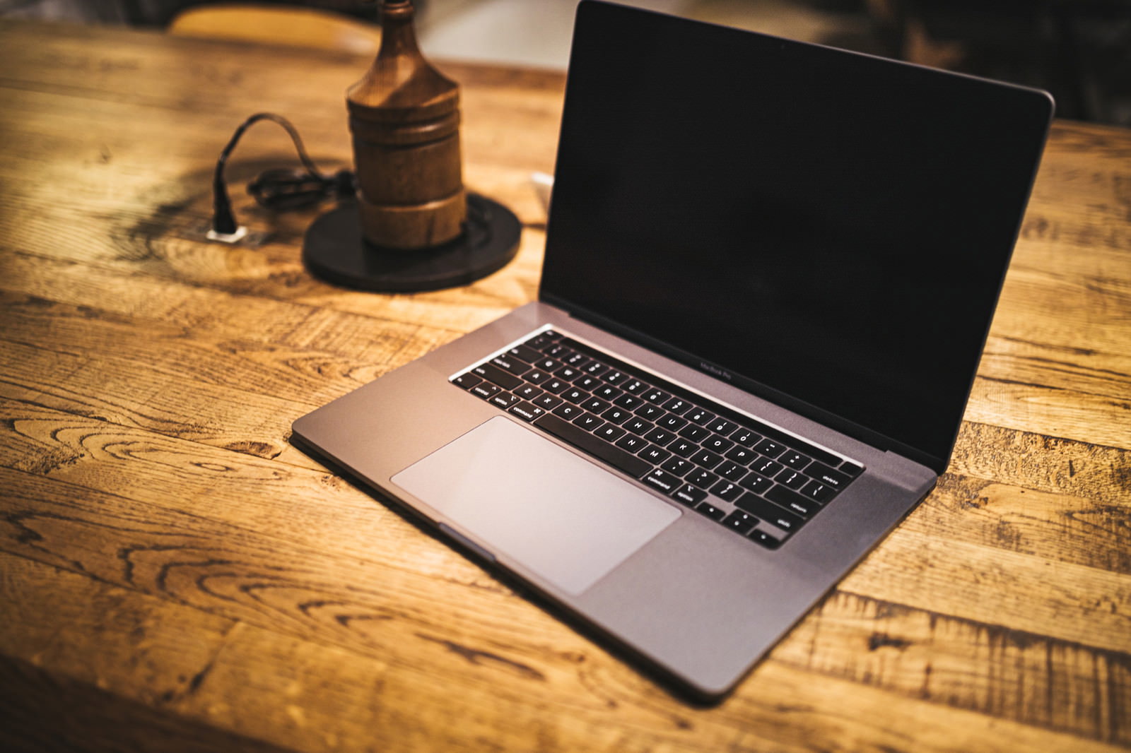 木製テーブルの上に開いて置かれたMacbookとガベル
