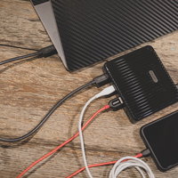 木目調デスクでスマホを複数機器同時充電する様子の写真